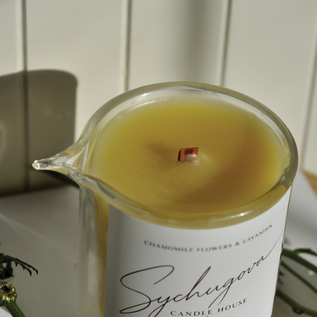 Close-up of the chamomile and lavandin massage candle with melted body oil texture and wood wick