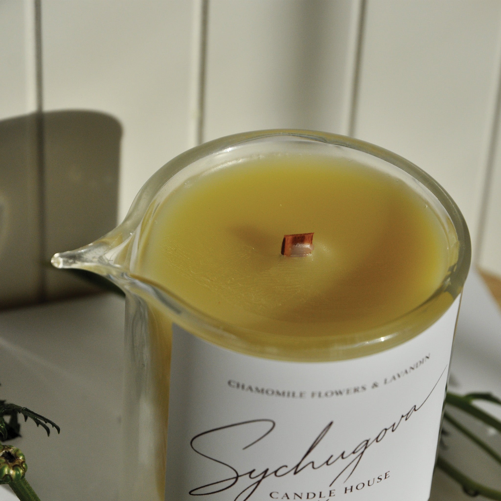 Close-up of the chamomile and lavandin massage candle with melted body oil texture and wood wick